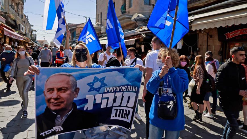 Supporters of Israeli Prime Minister Benjamin Netanyahu campaign at the Mahane Yehuda market in Jerusalem on February 26, 2021 ahead of the March 23 Israel general election. - Israel will hold its fourth general election in less than two years, on March 23. (Photo by MENAHEM KAHANA / AFP) (Photo by MENAHEM KAHANA/AFP via Getty Images)