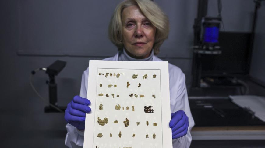 Israel Antiquities Authority (IAA) conservator Tanya Bitler displays recently-discovered 2000-year-old biblical scroll fragments from the Bar Kochba period, after completion of preservation work at the authority's Dead Sea conservation lab in Jerusalem, on March 16, 2021. - Israel described the find, which includes a cache of rare coins, a six-millennia-old skeleton of a child and basket it described as the oldest in the world, at over 10,000 years, as one of the most significant since the Dead Sea Scrolls.