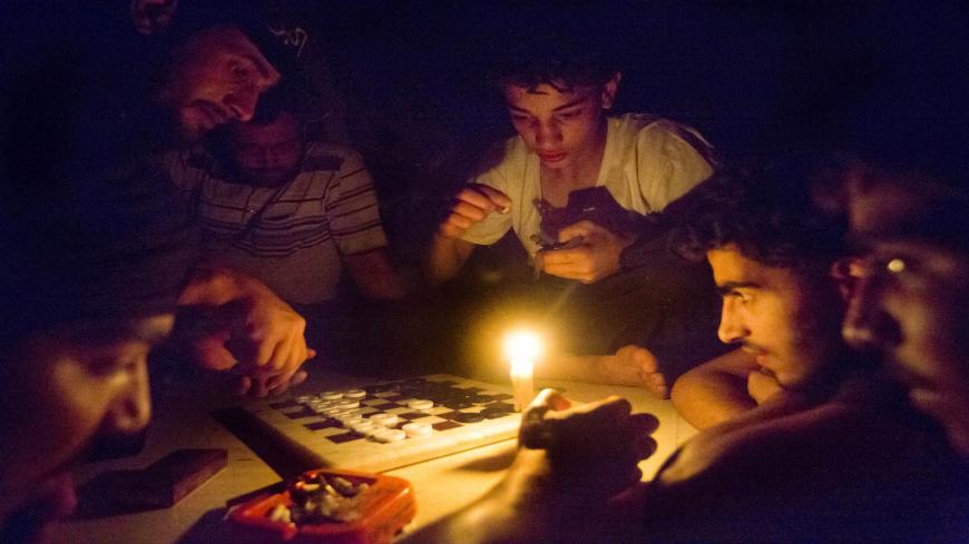 Syrian rebel fighters play a game by candle light, due to electricity cuts on May 26, 2013 in Adana, near the northeastern city of Deir Ezzor. Syria's opposition denounced as "too little, too late" an EU decision to lift an arms embargo on rebels fighting the regime of President Bashar al-Assad.  AFP PHOTO / RICARDO GARCIA VILANOVA        (Photo credit should read Ricardo Garcia Vilanova/AFP via Getty Images)