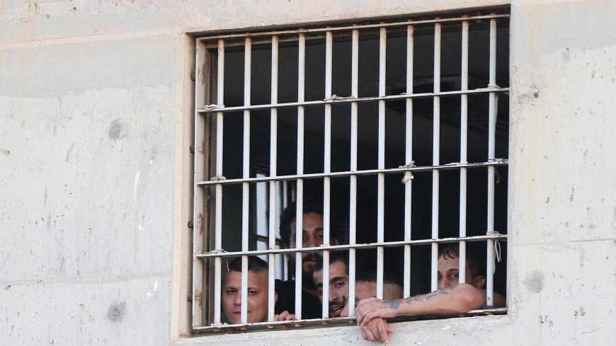 Jordanian detainees look on through the window of a rehabilitation centre in Zarqa, 30 kilometres east of Amman, on July 11, 2018. (Photo by Khalil MAZRAAWI / AFP)        (Photo credit should read KHALIL MAZRAAWI/AFP via Getty Images)