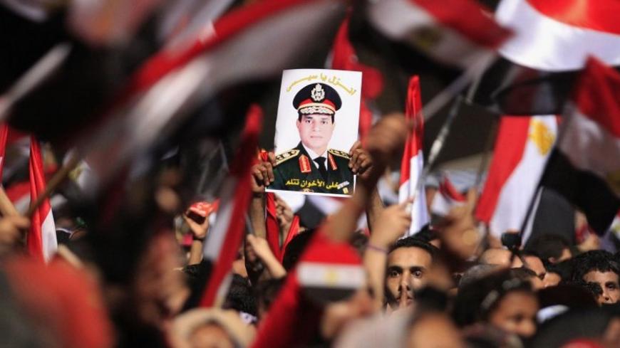 Protesters, who are against Egyptian President Mohamed Mursi, hold a poster featuring the head of Egypt's armed forces General Abdel Fattah al-Sisi in Tahrir Square in Cairo July 3, 2013. Egypt's armed forces overthrew elected Islamist President Mohamed Mursi on Wednesday and announced a political transition with the support of a wide range of political, religious and youth leaders. A statement published in Mursi's name on his official Facebook page after al-Sisi's speech said the measures announced amounte