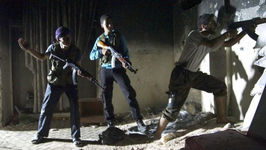 A member of the Free Syrian Army aims his weapon as fellow fighters stand behind him in Deir al-Zor July 22, 2013. Picture taken July 22, 2013. REUTERS/Khalil Ashawi (SYRIA - Tags: CONFLICT MILITARY CIVIL UNREST TPX IMAGES OF THE DAY) - RTX11VPZ
