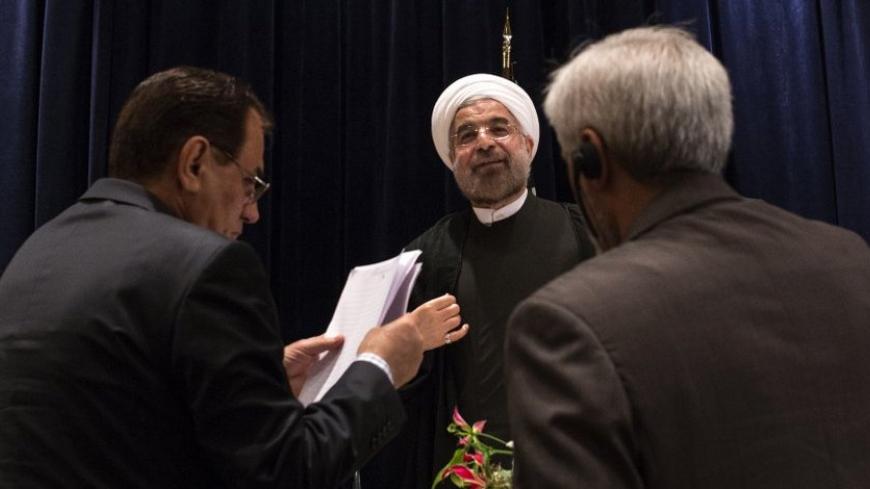 Iran's President Hassan Rouhani (C) is approached by staff members after a news conference in New York September 27, 2013.  New Iranian President Rouhani said on Friday he wanted talks with major powers on Iran's nuclear program to yield results in a short period of time and that the improved mood in U.S.-Iranian relations could lead to better ties.  REUTERS/Adrees Latif (UNITED STATES - Tags: POLITICS ENERGY) - RTX142AH