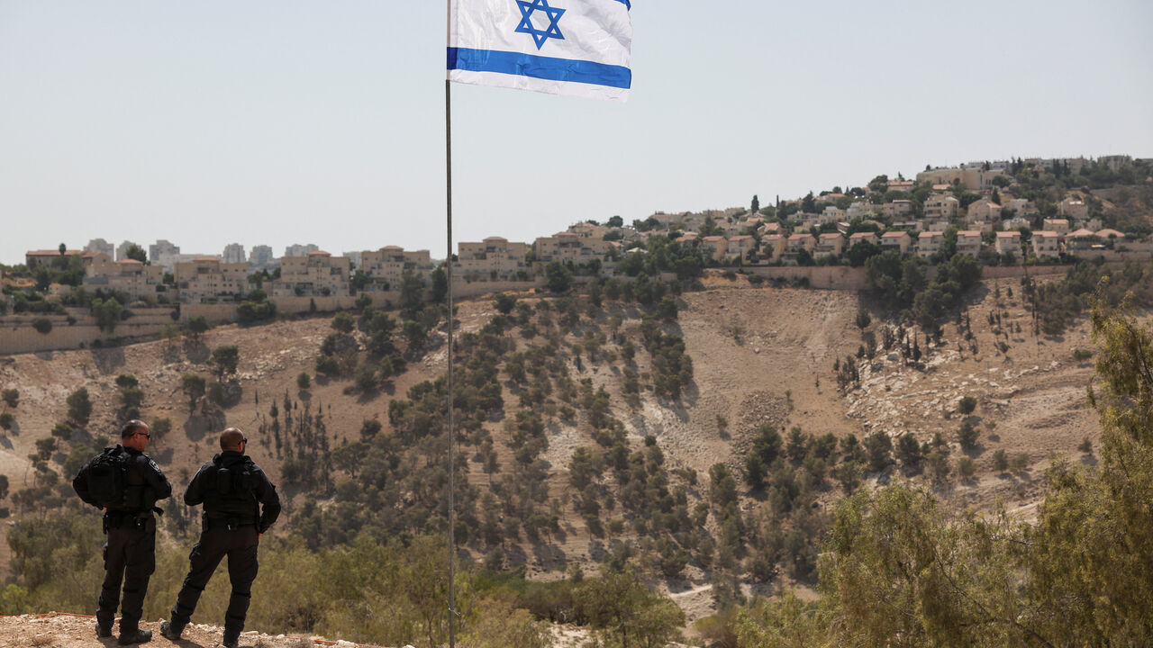 An Israeli flag flutters, as part of the Israeli settlement of Maale Adumim is visible in the background, in the Israeli-occupied West Bank, August 14, 2025. REUTERS/Ronen Zvulun