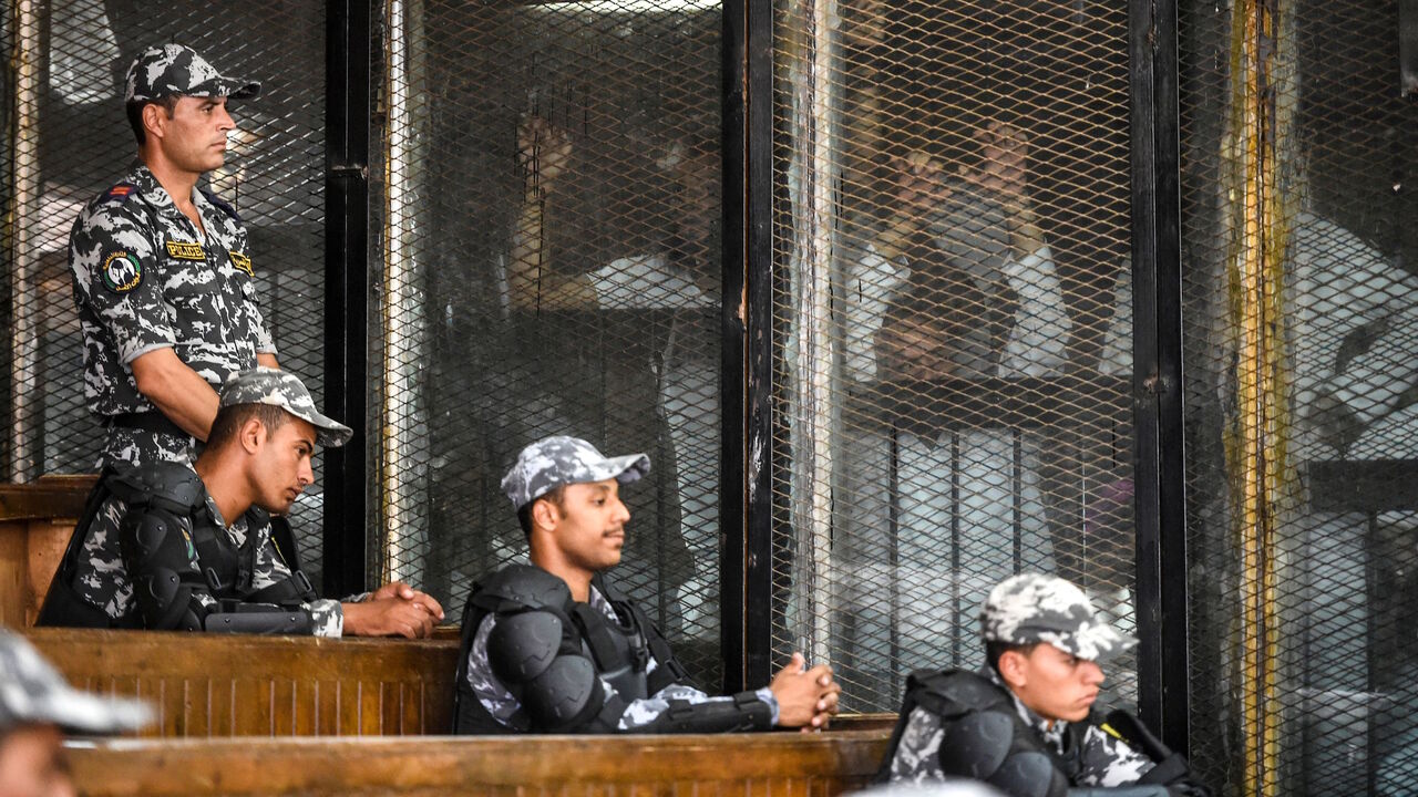 Members of Egypt's banned Muslim Brotherhood are seen inside a glass dock during their trial in the capital Cairo on July 28, 2018. 