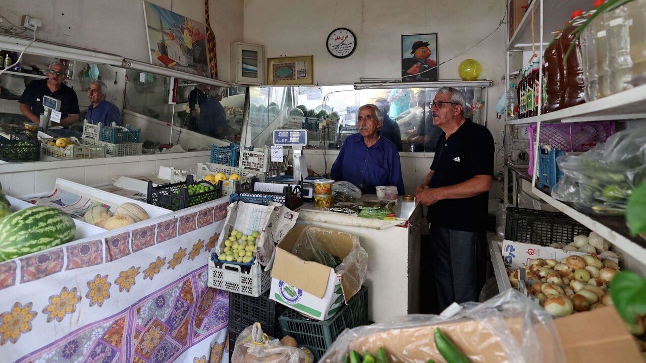 A vendor serves a costumer during a power outage in Iran's capital Tehran, on May 23, 2021.