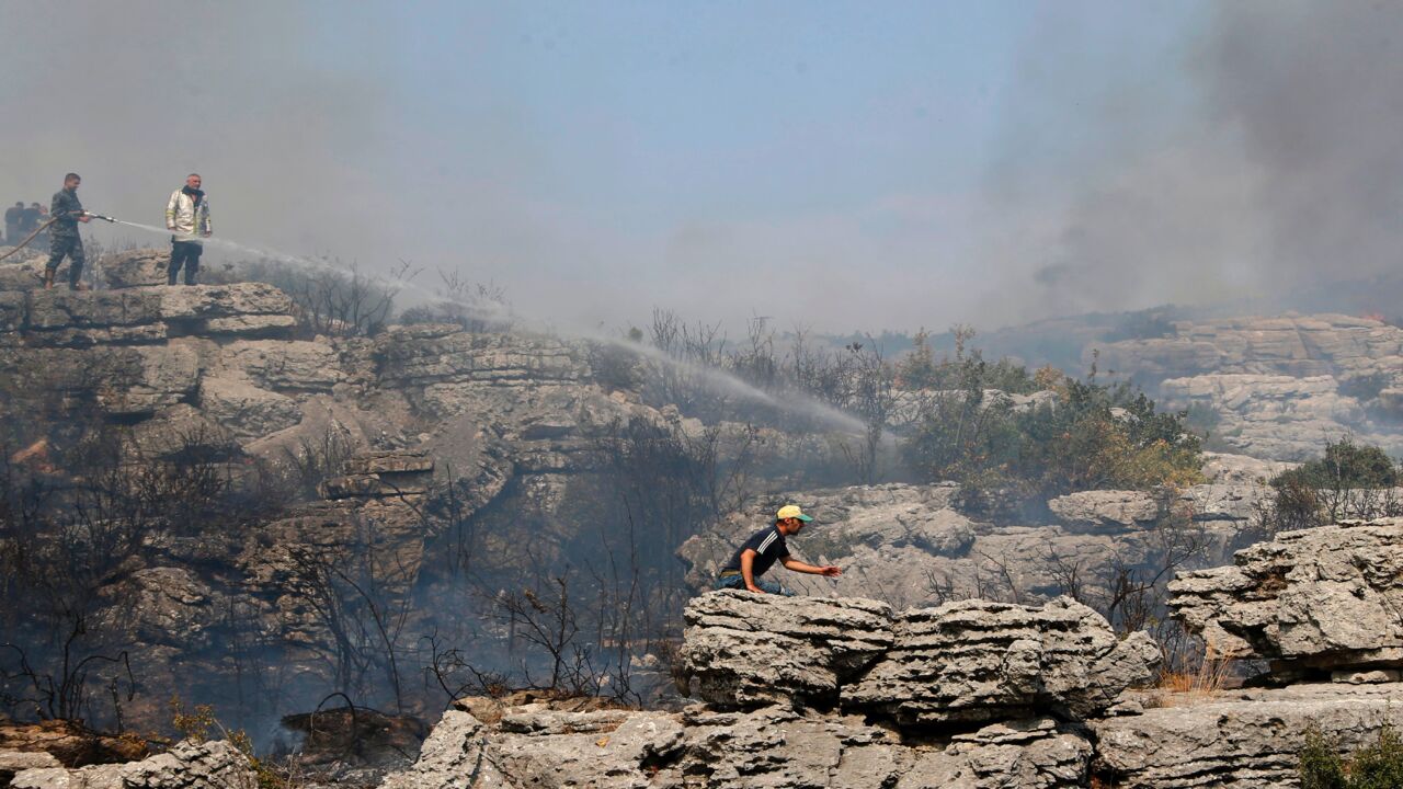 Syrian soldiers and locals battle a forest fire in the Ain Shams area west of Hama province, on Sept. 10, 2020. 