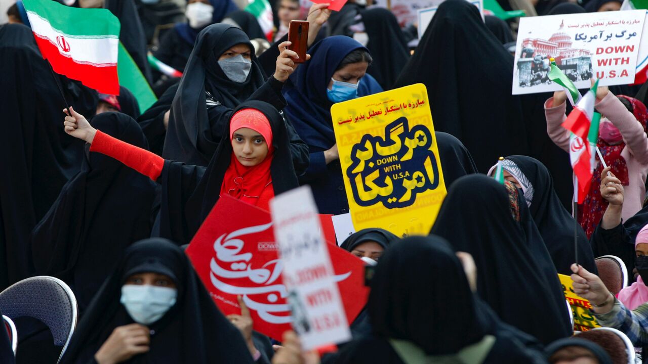 A young Iranian girl waving a national flag takes part in a rally outside the former US Embassy in the capital, Tehran, on Nov. 4, 2021.
