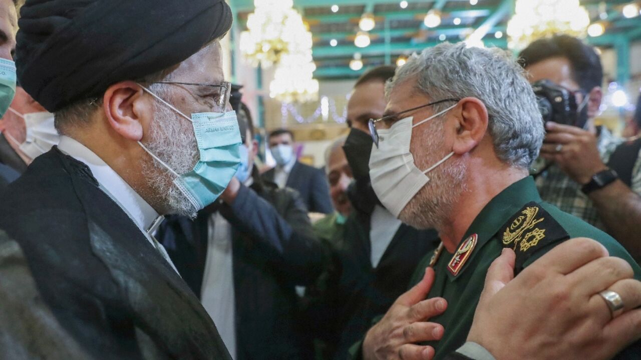 Iran's President Ebrahim Raisi (L) greets the head of the Revolutionary Guards' Quds Force Brigadier General Esmail Qaani at a Tehran ceremony to honour the families of those killed in the 1980-1988 Iran-Iraq war and veterans of that conflict