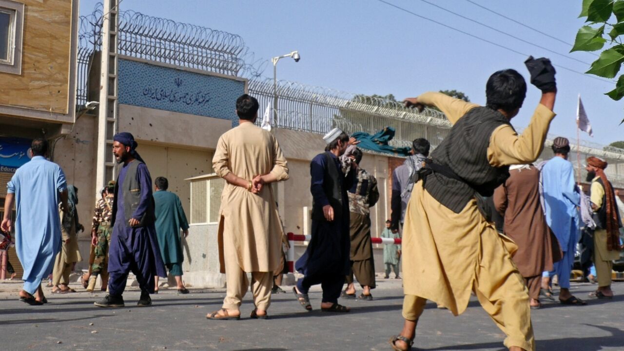 Afghan protesters throw stones at the Iranian consulate during a demonstration in Herat on April 11, 2022 after viral videos purportedly showed Afghan refugees being beaten by Iranians