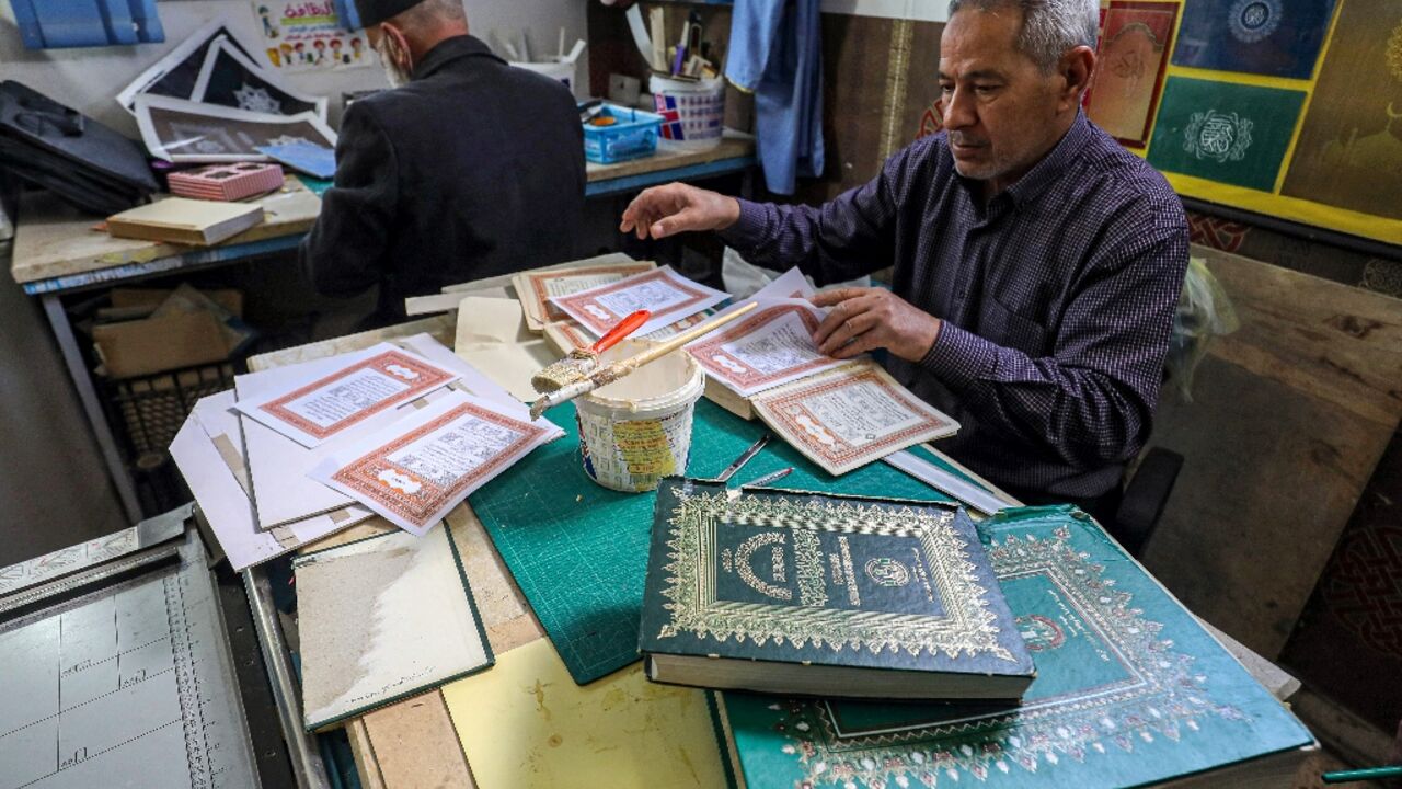 A man assembles pages together to be glued into a volume at a workshop for restoring copies of the Holy Koran, Islam's holy book -- an increasingly popular practice as the price of new Korans goes up in Libya