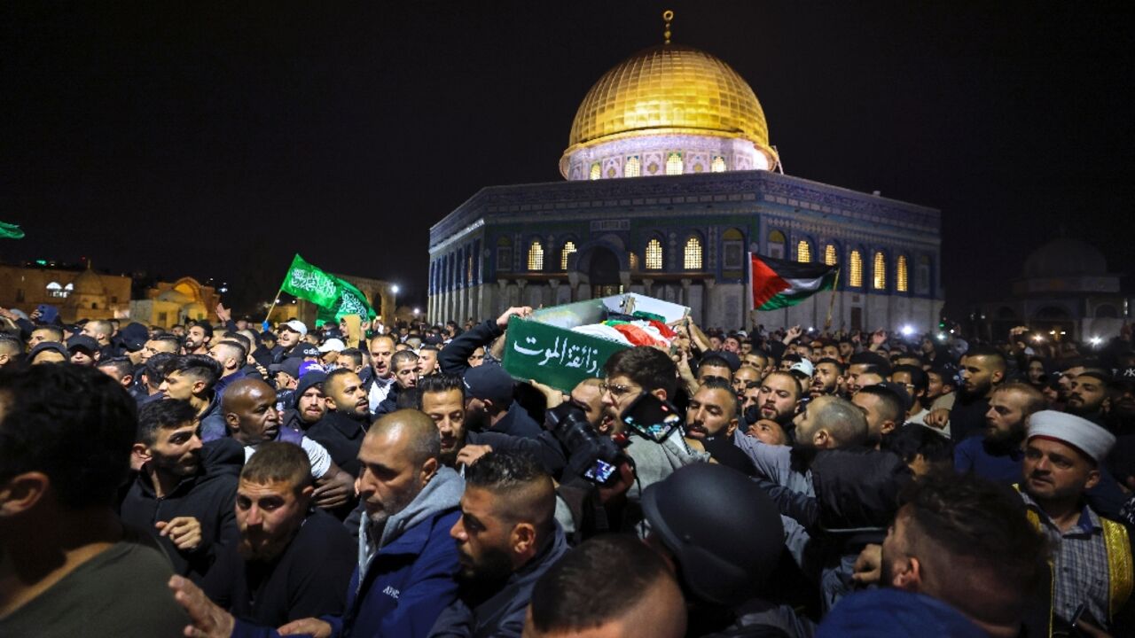 Palestinian mourners carry the body of Walid al-Sharif in front of the Dome of the Rock mosque at the Al-Aqsa compound