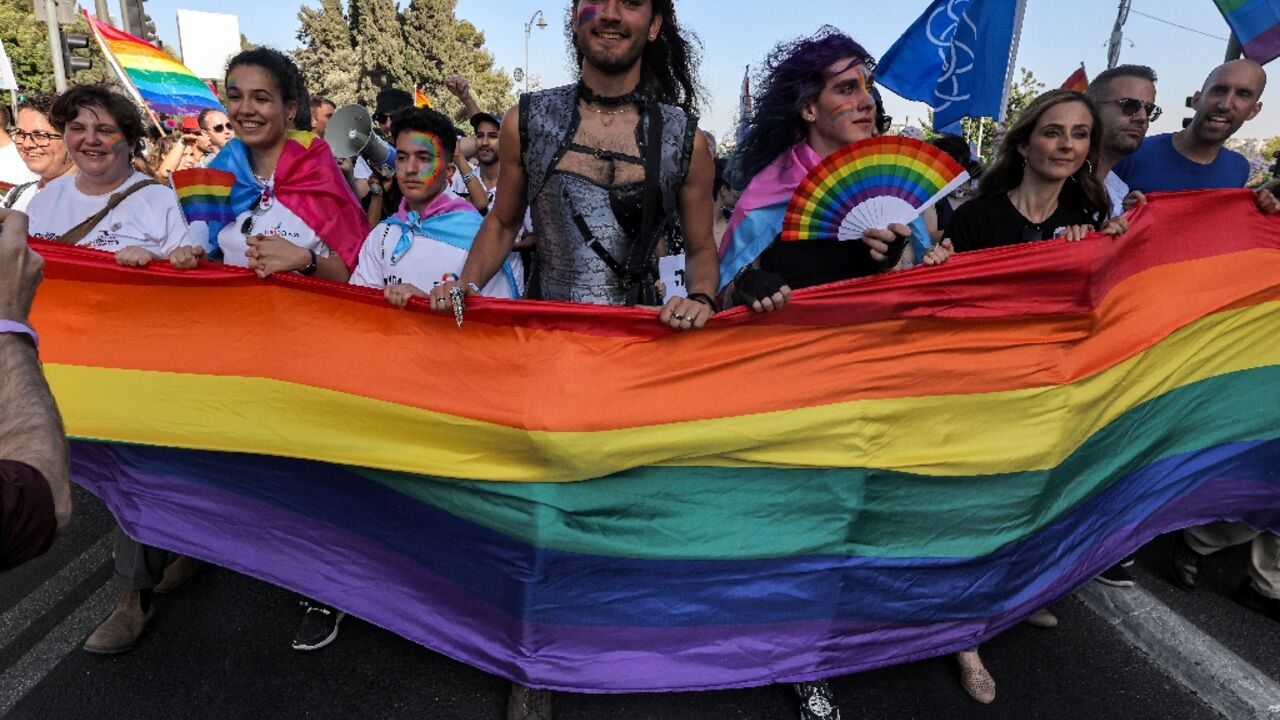 Participants march with a giant rainbow banner during the annual Jerusalem Pride Parade