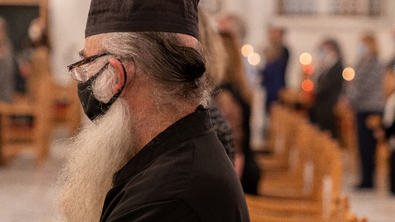 Mask-clad Greek Orthodox Cypriot priest attends mass at a church in the capital Nicosia