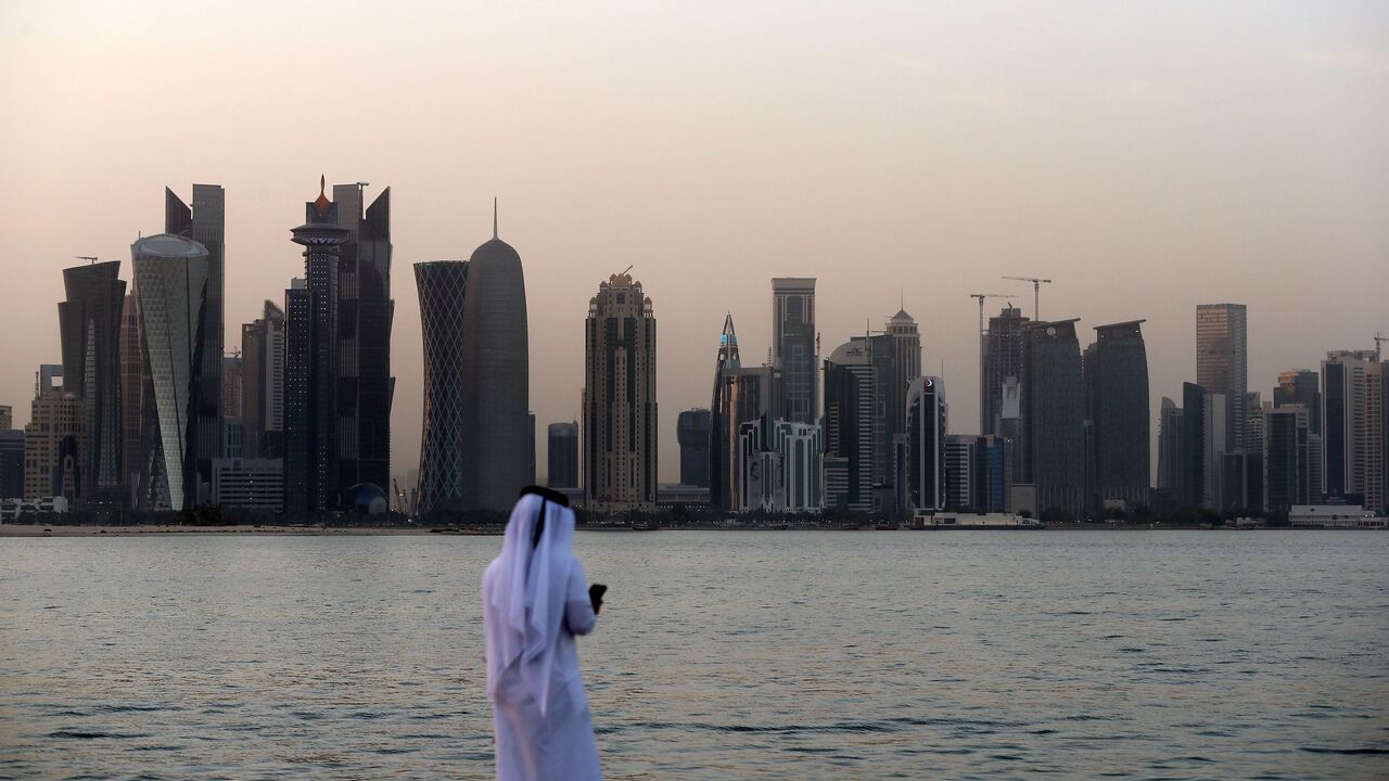 A man looks at his phone on the corniche in the Qatari capital Doha on July 2, 2017.