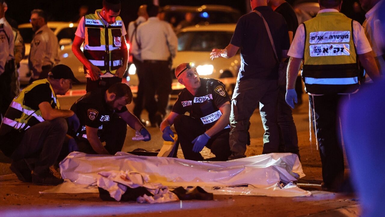 Israeli rescuers and security forces gather round the body of a man shot dead by police after a stabbing attack near Ramallah on September 22, 2022