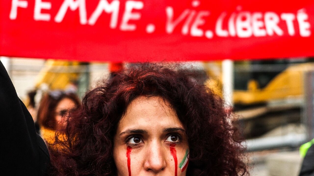 A protestor with red tears painted on her face during a rally in support of the demonstrations in Iran, in Toulouse, south-western France, on December 3