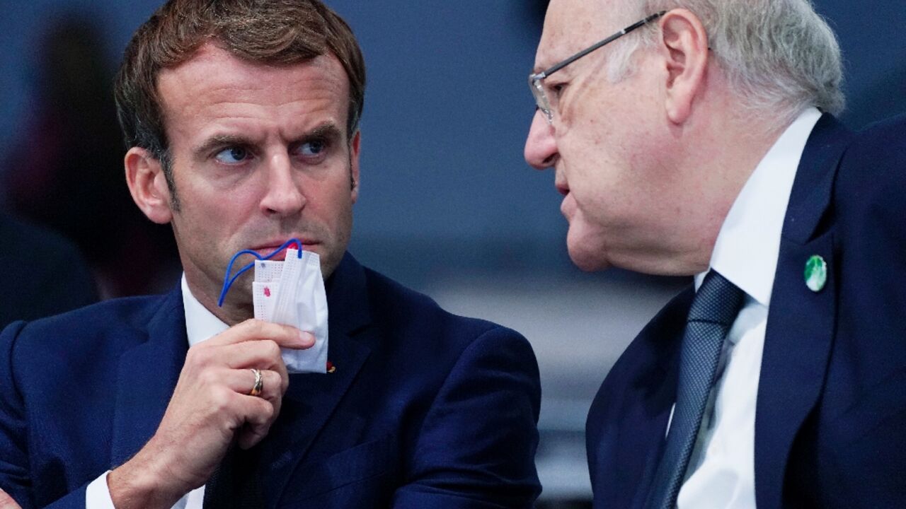 French President Emmanuel Macron (L) speaks with Lebanese Prime Minister Najib Mikati on the sidelines of UN climate change talks in Glasgow late last year
