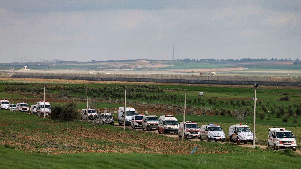 A convoy of Palestinian ambulances move along the border fence between Israel and the Gaza Strip on January 9 