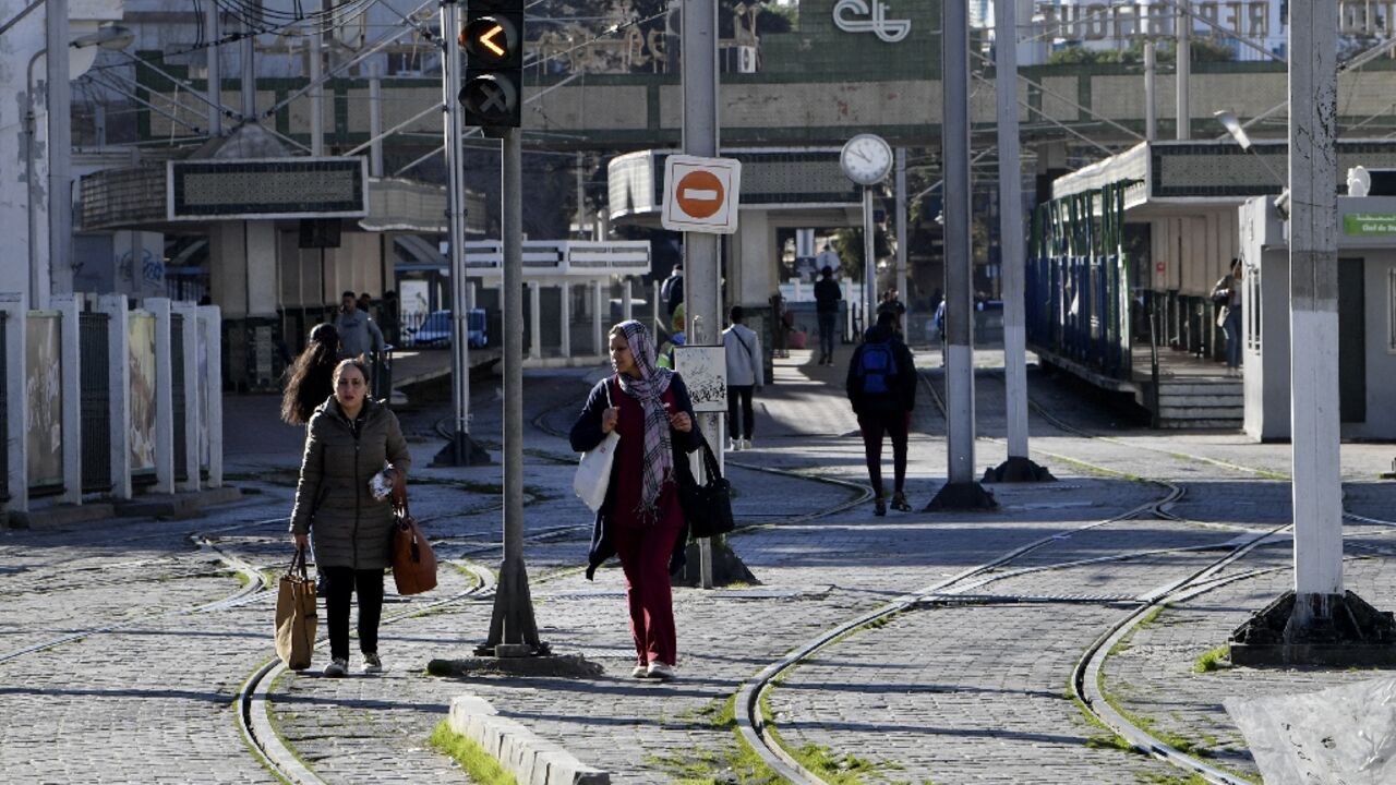 Tunisians are pictured next to a tram station in the capital Tunis during a public transport employee strike on Monday
