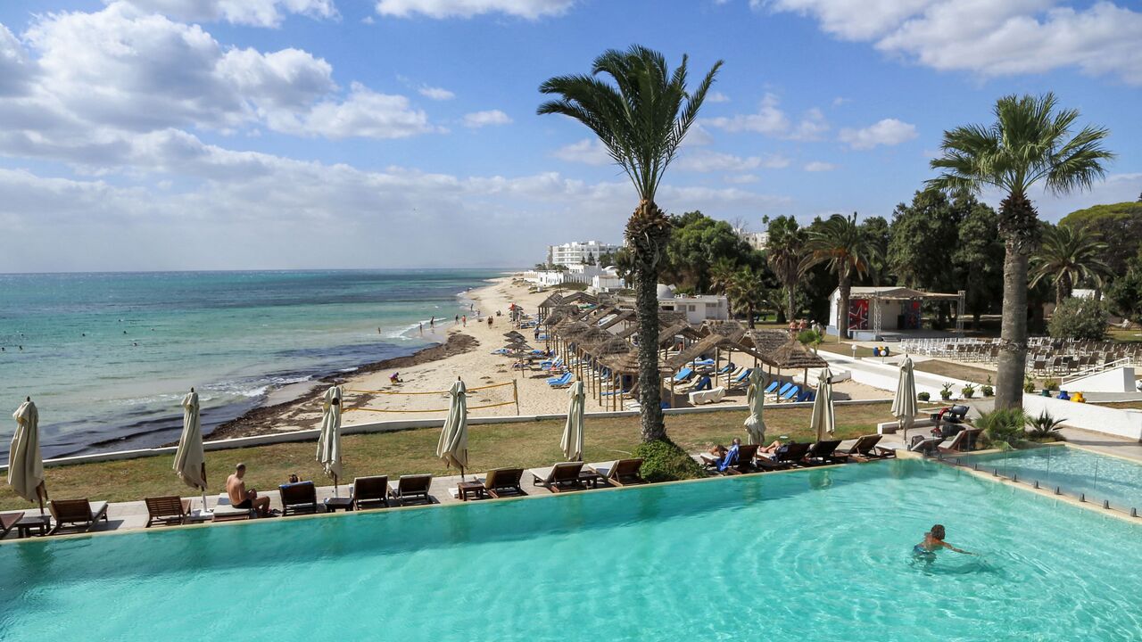 A tourist swims in a swimming pool at a hotel in Tunisia's resort town of Hammamet, about 66 kilometres south of the capital Tunis, on October 7, 2021. - The October sun warms the sands of Hammamet beach on the Tunisian coast, but the coronavirus pandemic still casts a shadow, and visitors are few on the ground. After two ruined seasons in a row, operators in Tunisia are licking their wounds and hoping the lifting of travel restrictions will spell better days. (Photo by ANIS MILI / AFP) (Photo by ANIS MILI/