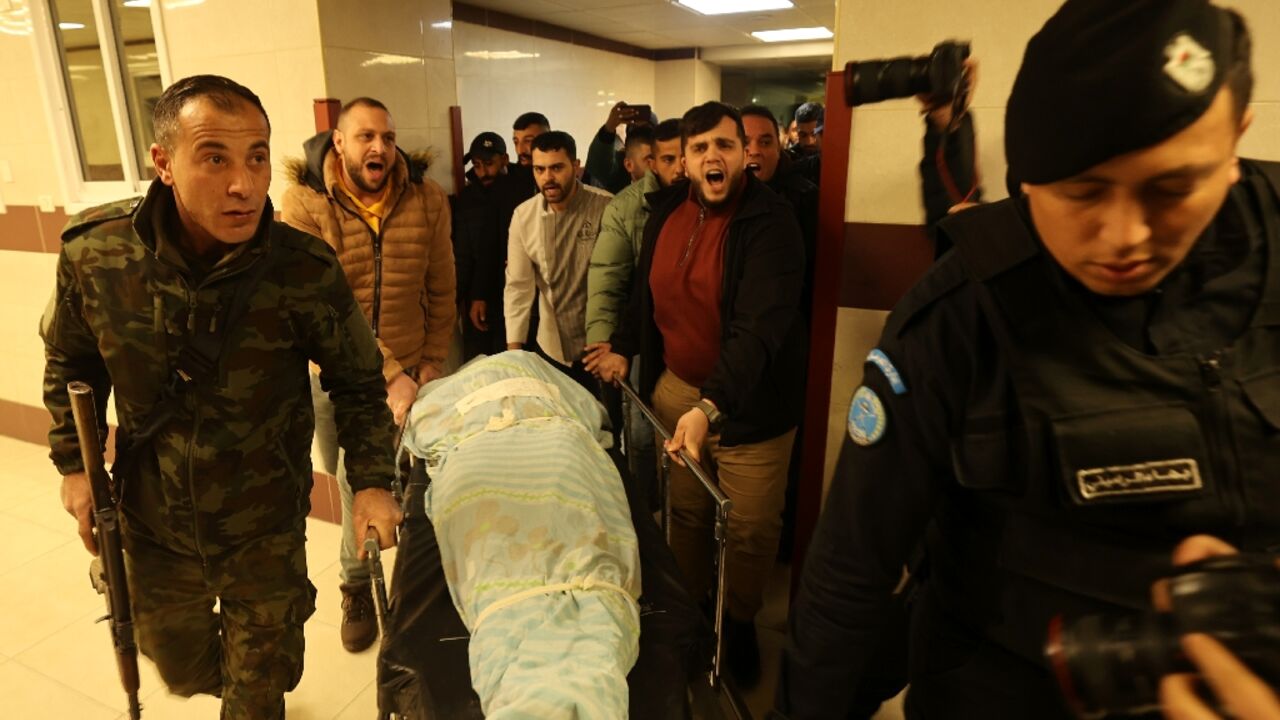 Mourners escort the body of Abdullah Qalalweh, who was reportedly shot dead by Israeli police near the Huwara checkpoint, out of the Rafidiya hospital in the West Bank city of Nablus