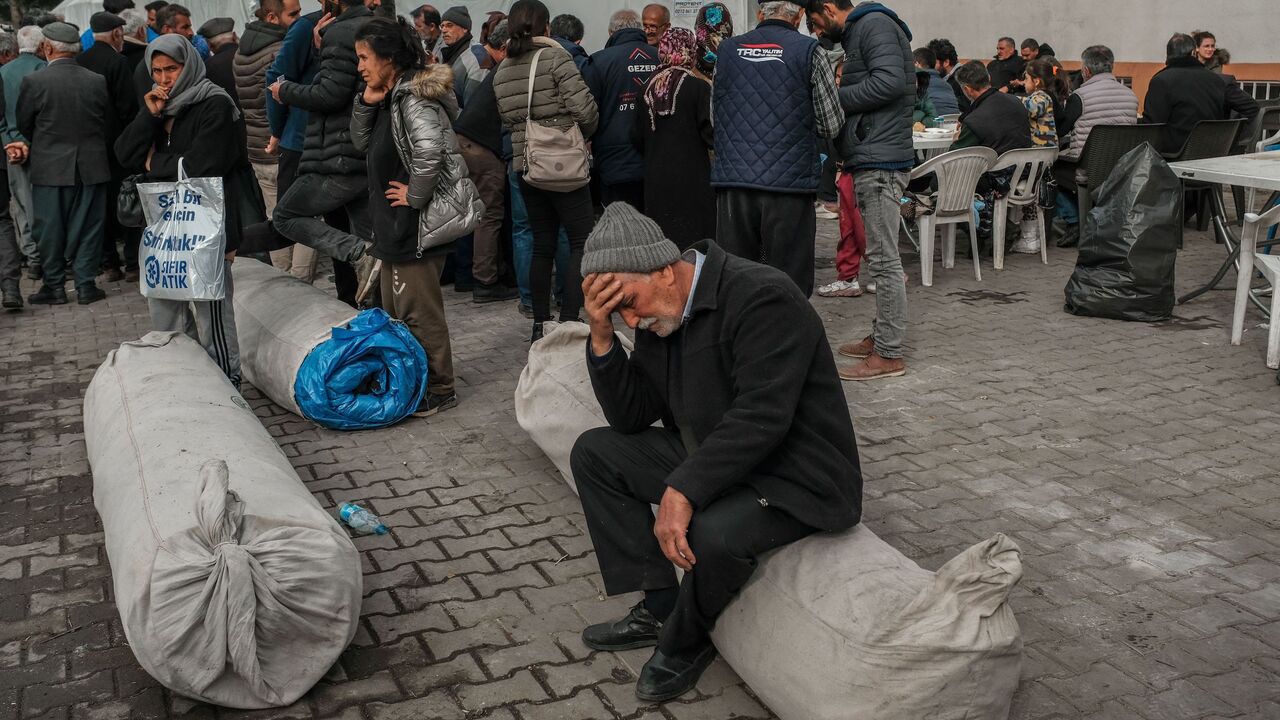 A man sits atop a rolled-up tent in the garden of Yenimahalle Cemevi.