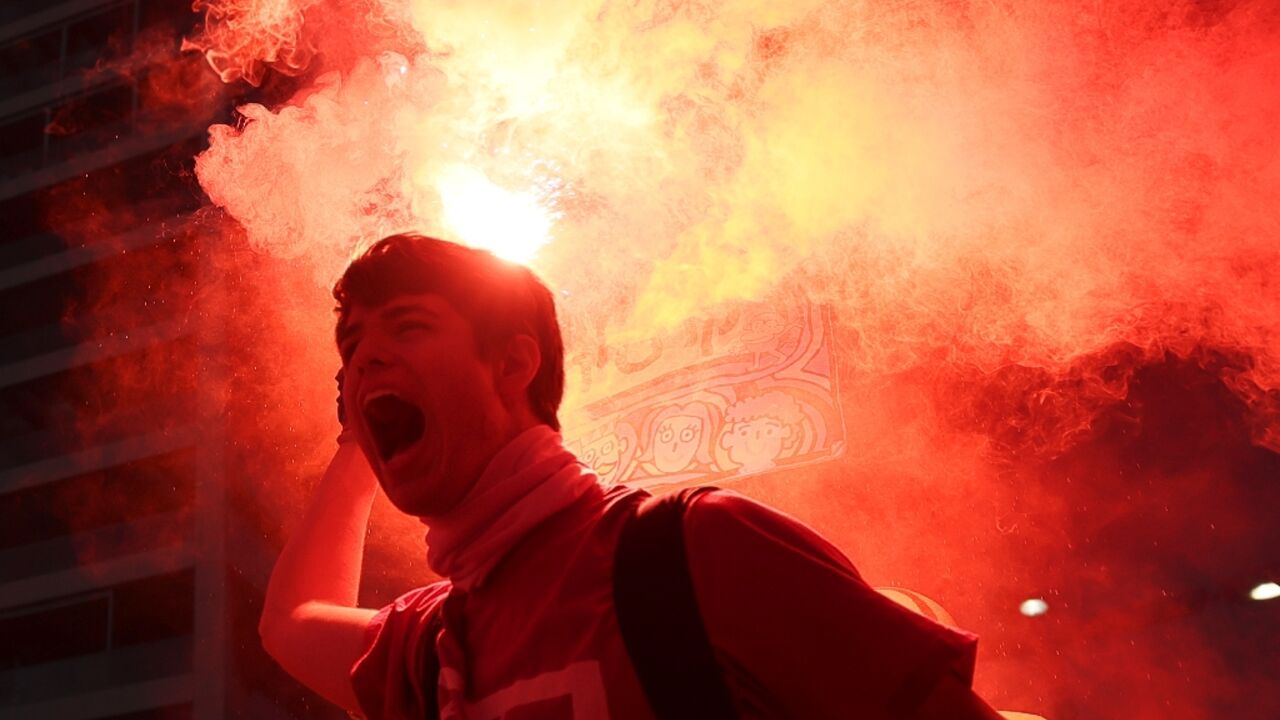 A protester brandishes a flare during protests in Tel Aviv against the government's judicial reform bill