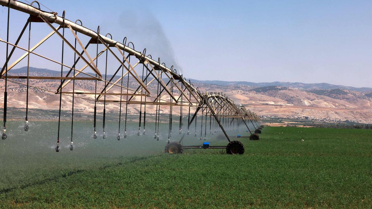 A picture taken on July 21, 2021, shows a center-pivot irrigation system spraying water in agricultural fields near the border with Jordan (background), south of the Sea of Galilee, or Lake Tiberias, one of the main water sources in Israel. As scientific warnings of dire climate change-induced drought grow, many in Israel and Jordan cast worried eyes at the river running between them and the critical but limited resources they share. (Photo by MENAHEM KAHANA / AFP) (Photo by MENAHEM KAHANA/AFP via Getty Ima