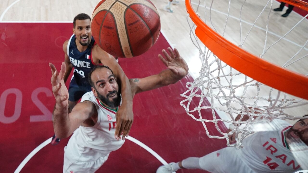 Hamed Haddadi (C) battling under the basket against France at the Tokyo Olympics 