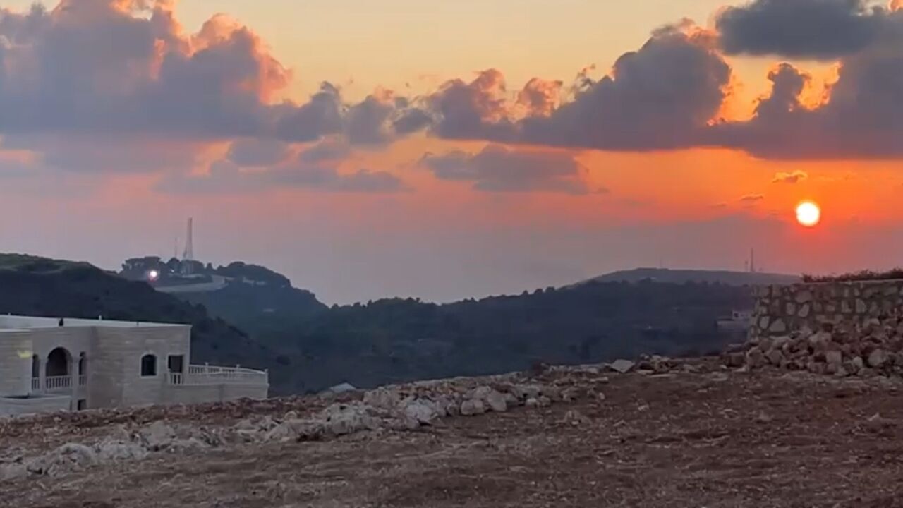 This grab taken from footage shot by AFP videographer Dylan Collins shows a flash of light (L) coming from an Israeli position the instant before the journalists were hit