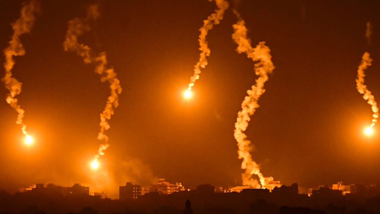 This picture taken from a position near Sderot along the Israeli border with the Gaza Strip on November 5, 2023, shows flares dropped by Israeli forces above the Palestinian territory