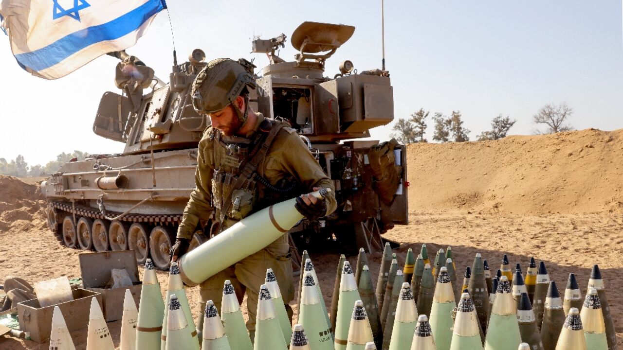 An Israeli soldier arranges artillery shells at a position near the border with the Gaza Strip