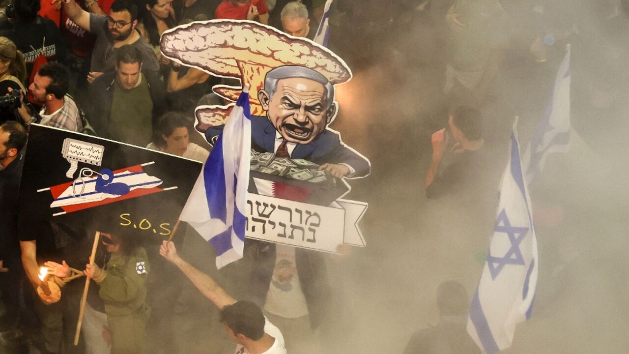 Israeli protesters demonstrate against the government's conduct of the Gaza war, holding up caricatures of Israeli Prime Minister Benjamin Netanyahu and demanding a snap election