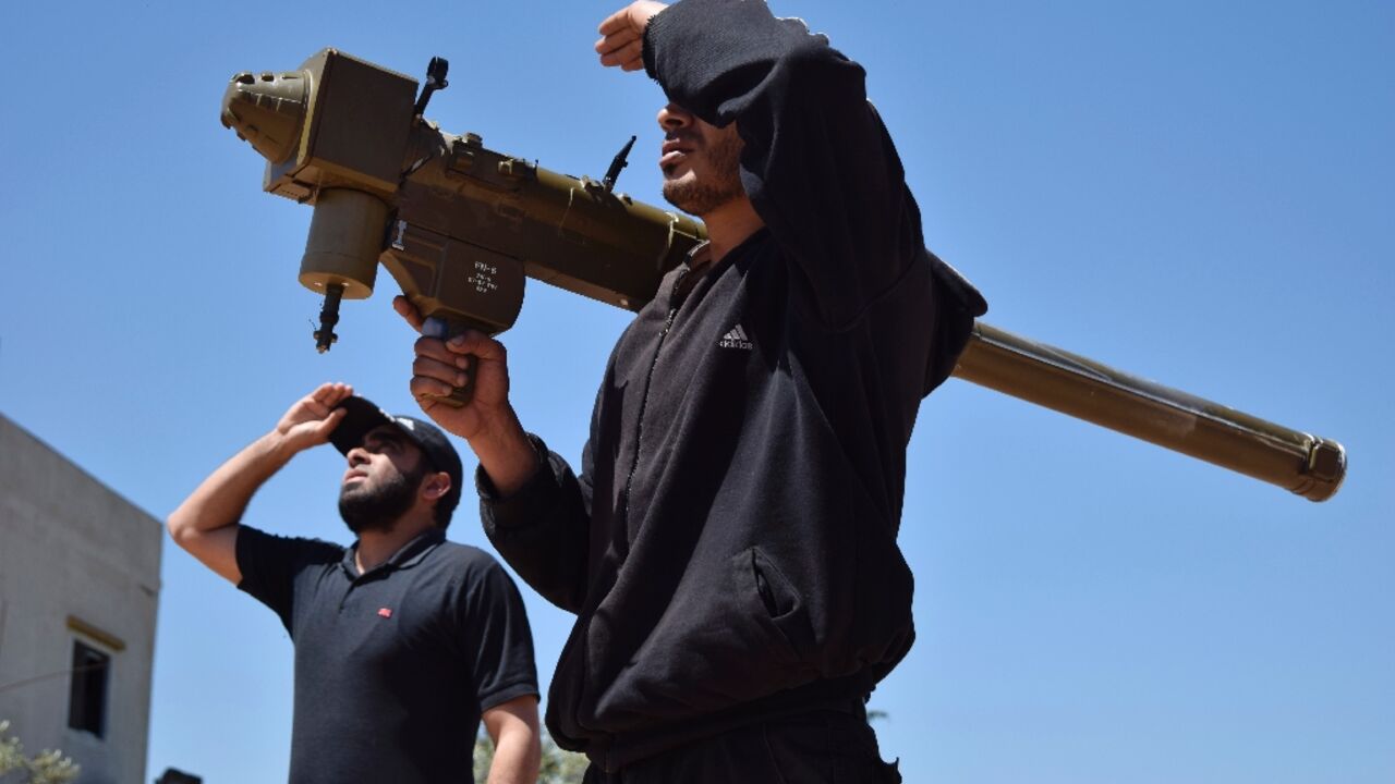 Rebel fighters monitor the sky holding a FN-6 man-portable air-defence system (MANPADS) in the Syrian village of Teir Maalah in 2016