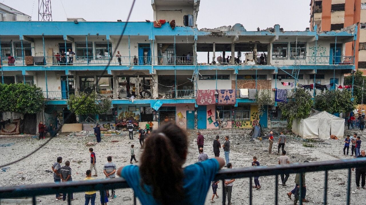 A girl watches as others check a UN-school housing displaced people that was hit during Israeli bombardment in Nuseirat on June 6, 2024