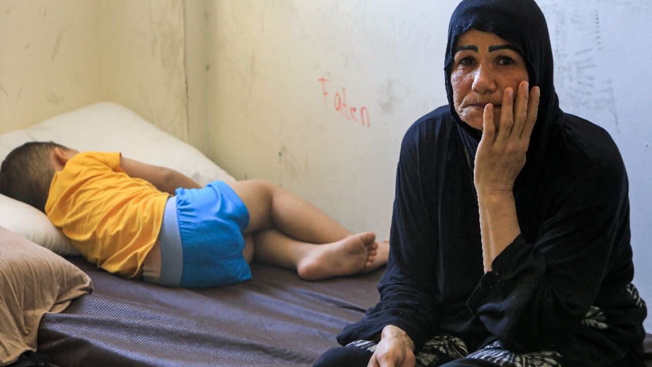 A child and a woman displaced by conflict from southern Lebanon take refuge at a school-turned-shelter in Beirut