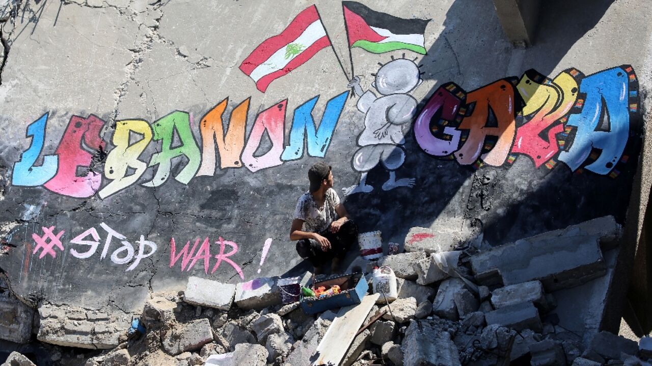 A Palestinian artist has painted a mural on the remains of a flattened Gaza building, in a message of solidarity with Lebanon