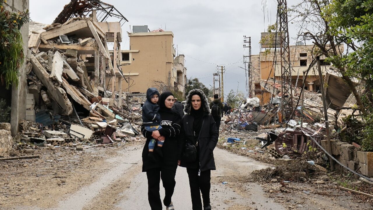 Residents walk amid the destruction in the southern Lebanese village of Zibqin after a ceasefire between Hezbollah and Israel allowed them to return home
