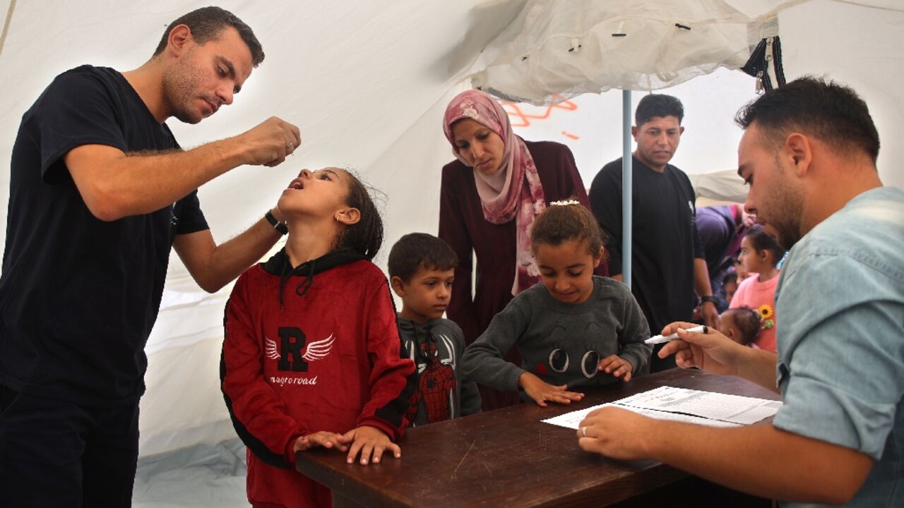 A medic administers polio vaccine to a Palestinian child at Abdel Aziz Rantissi hospital in the Gaza City area of north Gaza -- the campaign resumed after a halt due to Israeli bombing