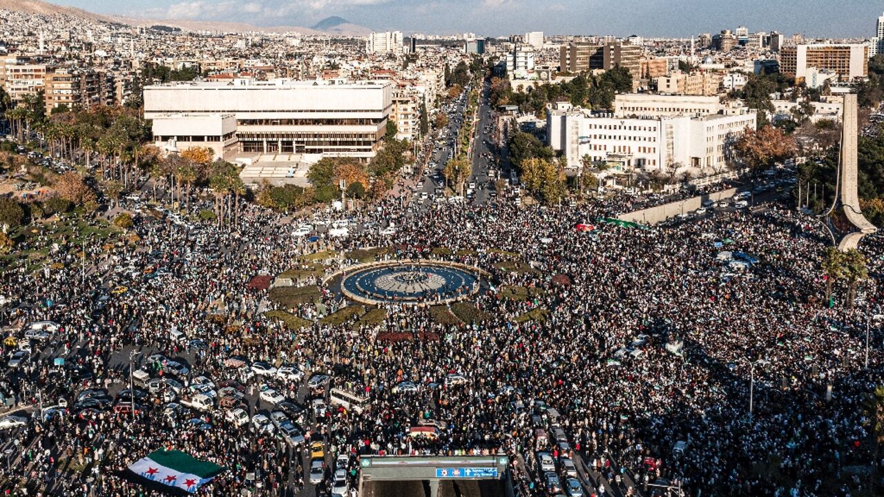 An aerial view of thousands celebrating the ouster of Syria's president Bashar al-Assad near the landmark Damascus Sword sculpture at Umayyad Square in central Damascus