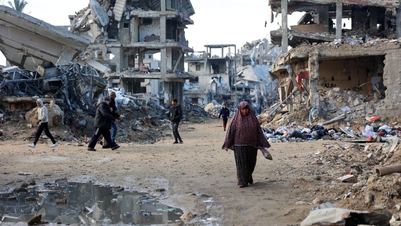 Palestinians walk amid the destruction in the Shujaiya neighbourhood of Gaza City