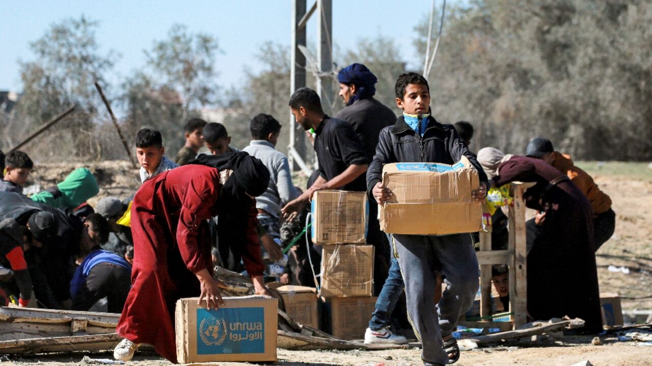 A boy in Al-Shoka receives an aid package provided by UNRWA.