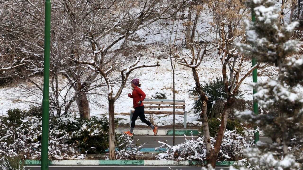 Not too cold for exercise: a woman in Tehran jogs amid the snow
