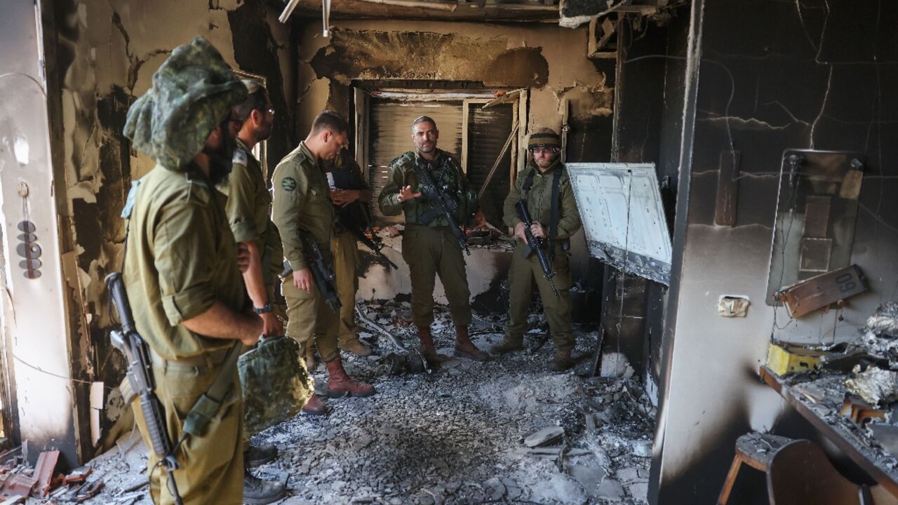 Ten days after Hamas's October 7, 2023 attack, Israeli troops inspect the damage to Kibbutz Beeri, the community hardest hit