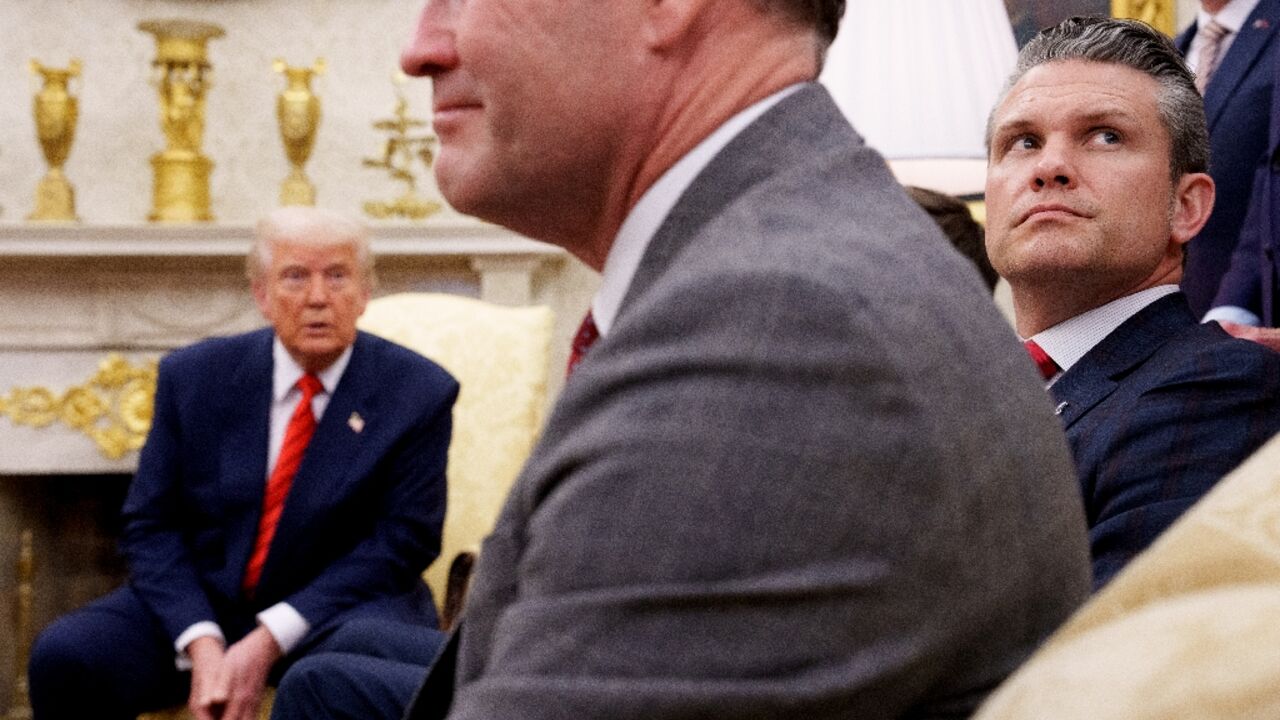 US National Security Advisor Michael Waltz (C) and Defense Secretary Pete Hegseth (R) are seen at a White House meeting with President Donald Trump on March 13, 2025 