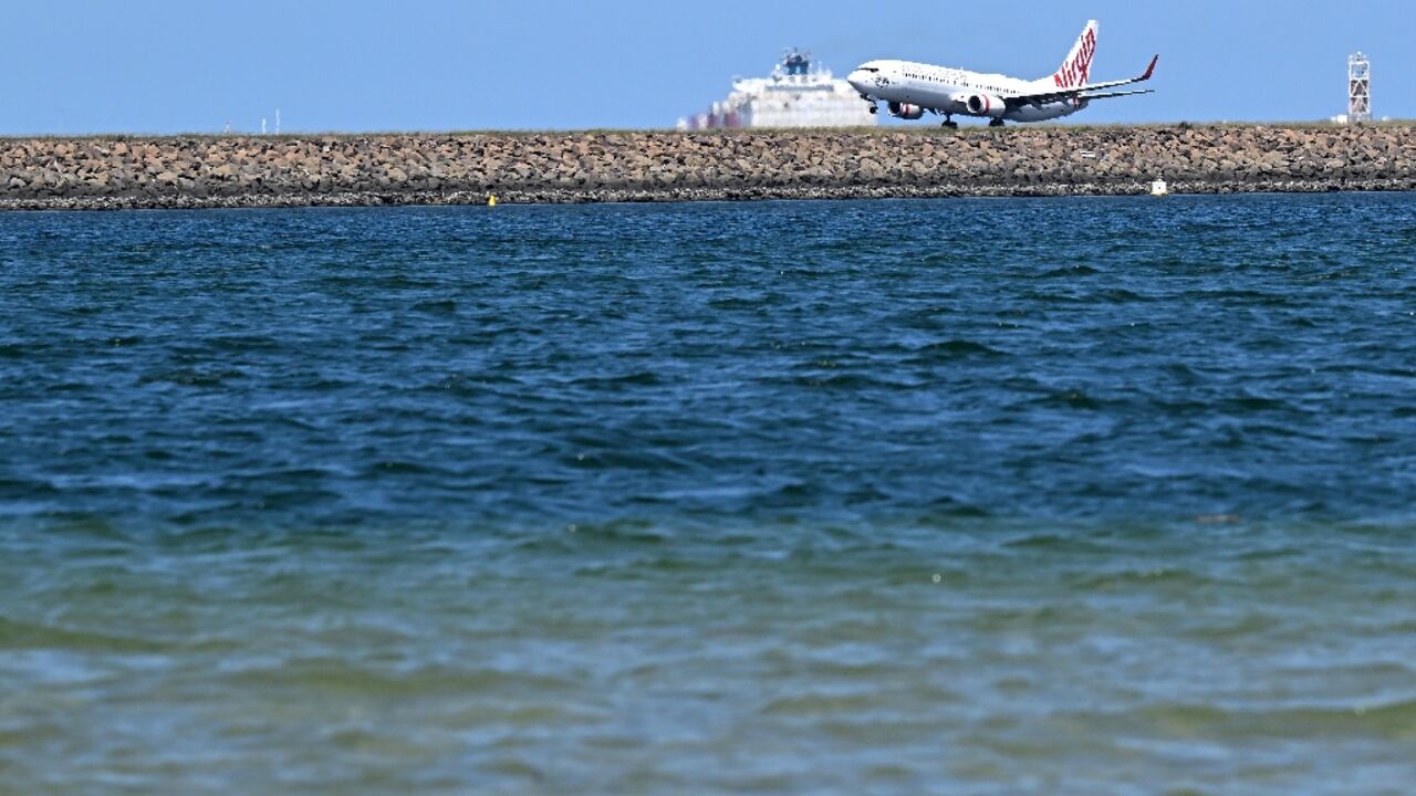 A Virgin Australia plane touches down at Sydney International Airport on February 27. Australia will let Qatar Airways buy a 25 percent stake in troubled Virgin Australia