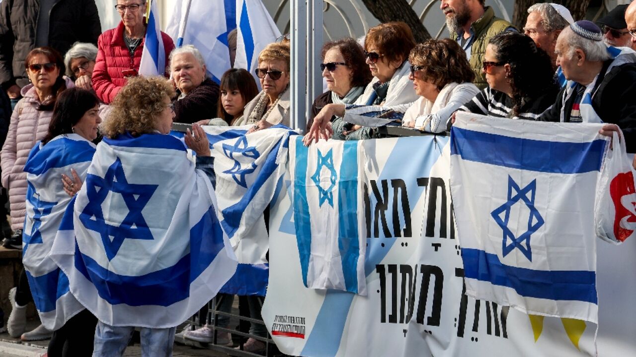 Des Israéliens attendent le passage du convoi funéraire de l'ex-otage franco-israélien Ohad Yahalomi, à Rishon Letzion, dans le centre d'Israël, le 5 mars 2025 