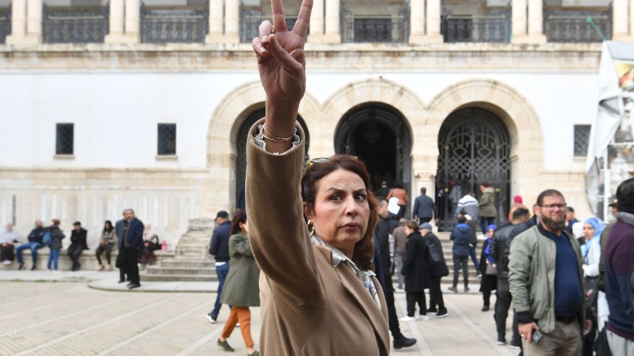 Dalila Ben Mbarek, lawyer and member of the defence committee of detainees accused of involvement in a conspiracy case against state security, flashes the victory sign as she arrives for the first hearing