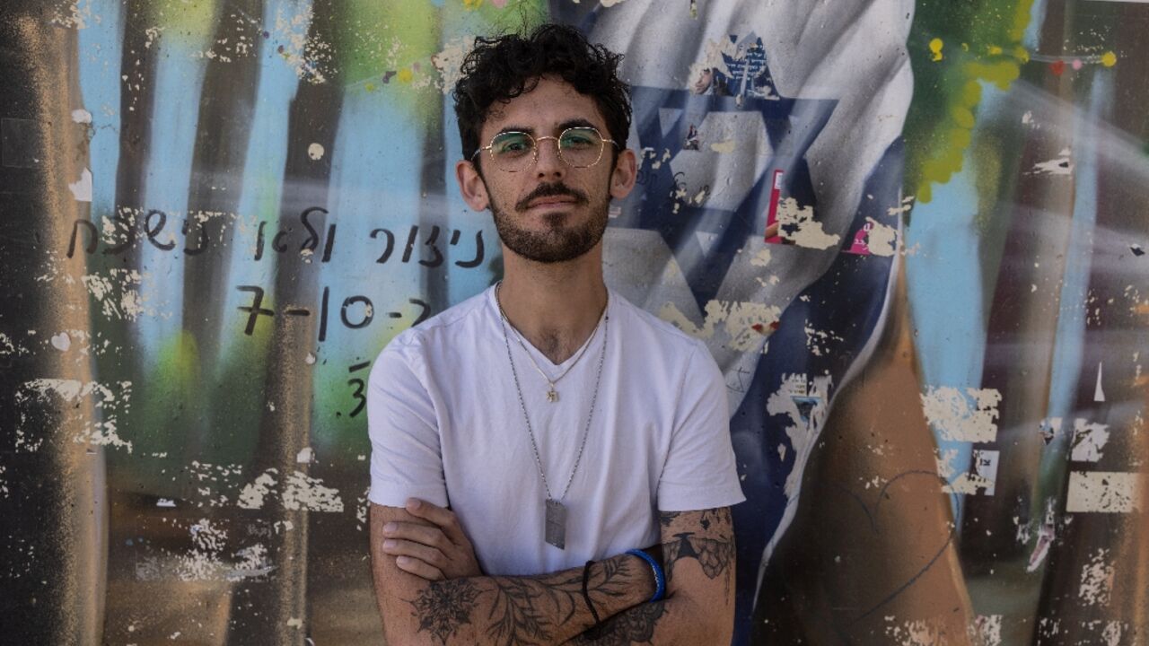 Shye Klein-Weinstein, a 28-year-old survivor of the October 7, 2023 attacks by Palestinian militants, poses for a picture next to a memorial to the Nova music festival victims